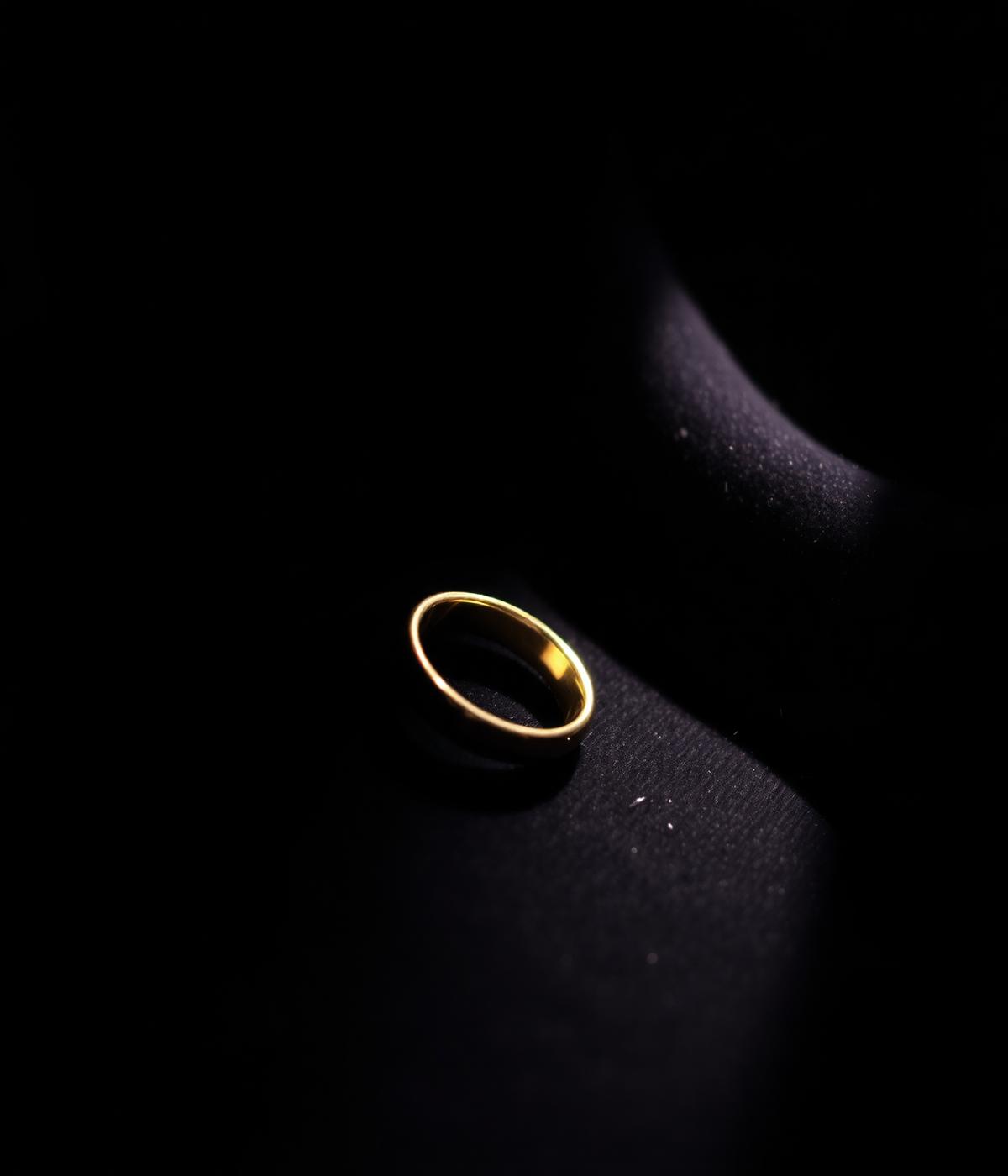 Une bague en or posée sur du velours sombre